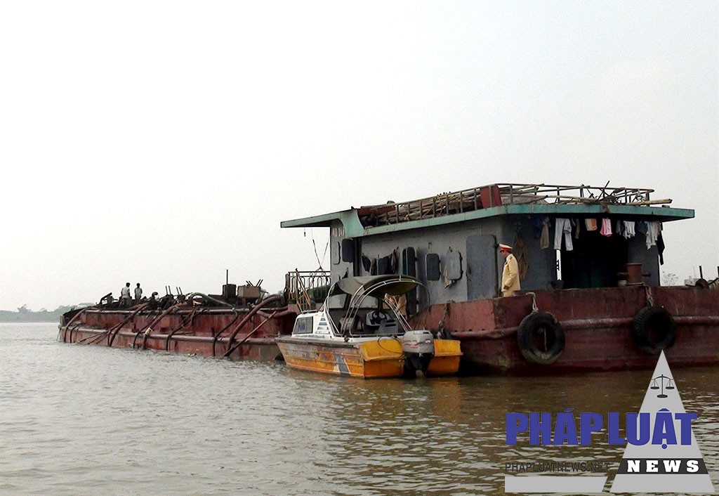 Công an tỉnh Bắc Ninh kiểm tra một sà lan khai thác cát trên sông Cầu - Ảnh: Hùng Thái